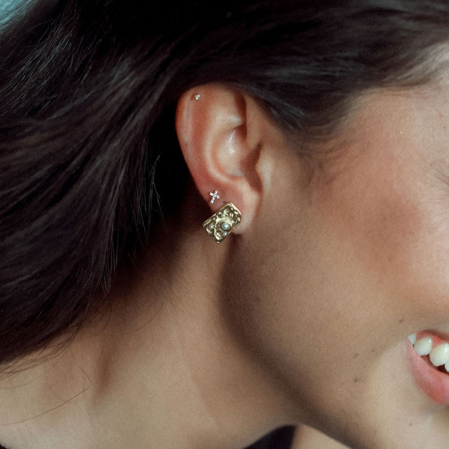 Close-up of a woman wearing a gold earrings with pearls