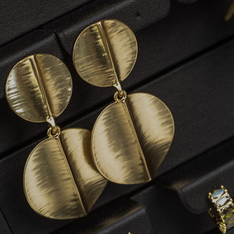 Gold earrings on a black jewelry box
