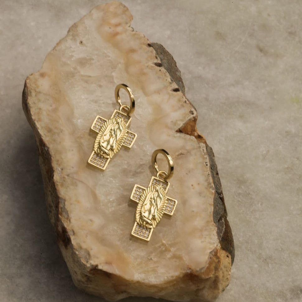 Gold cross pendants on a stone surface