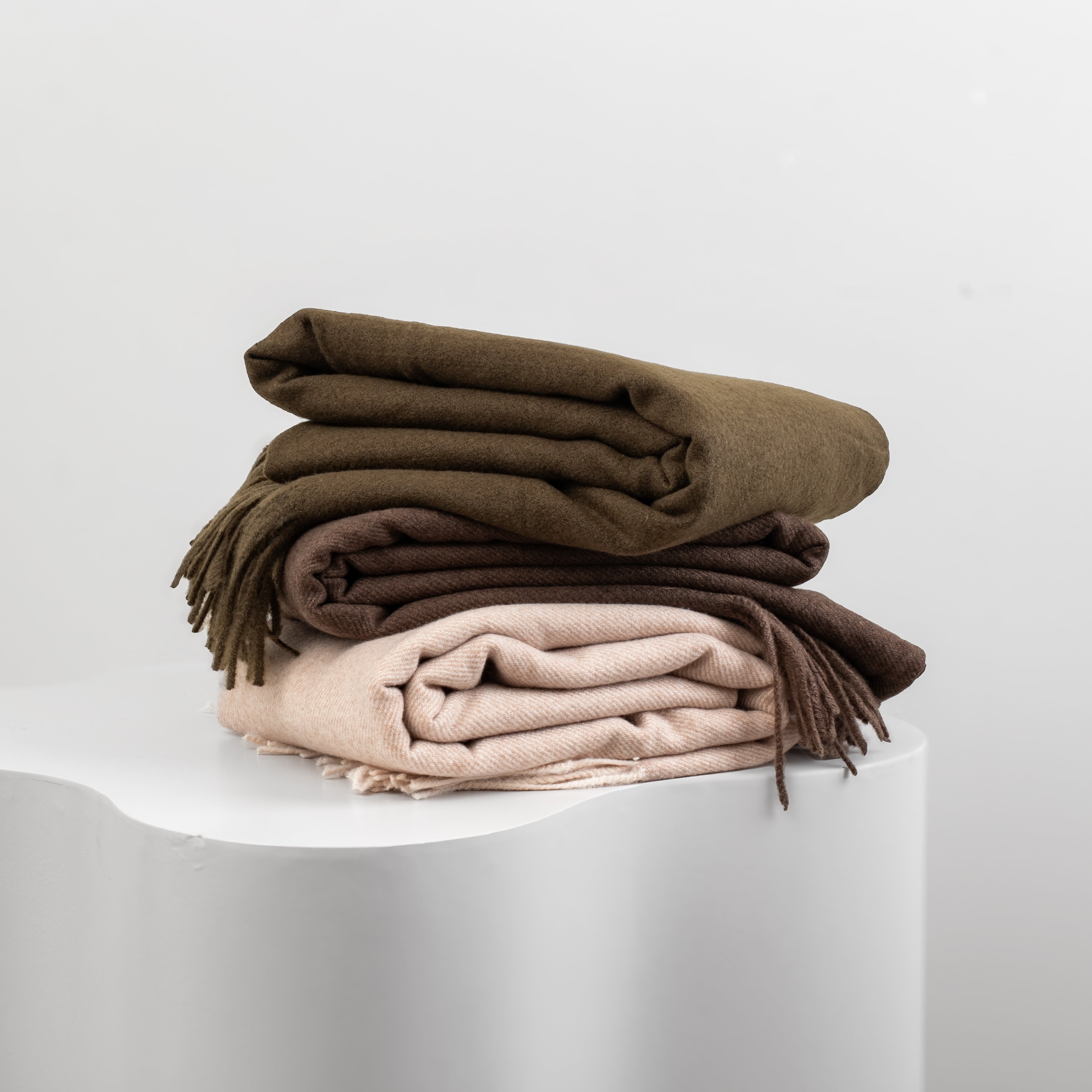 Stack of folded scarves in Chocolate, Olive and Cream
