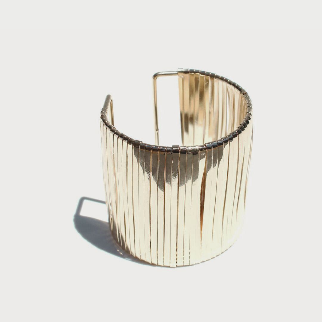 Queen of the Foxes Celestial Cuff in gold-plated brass, showing its wide shape, fine vertical bands and open back.