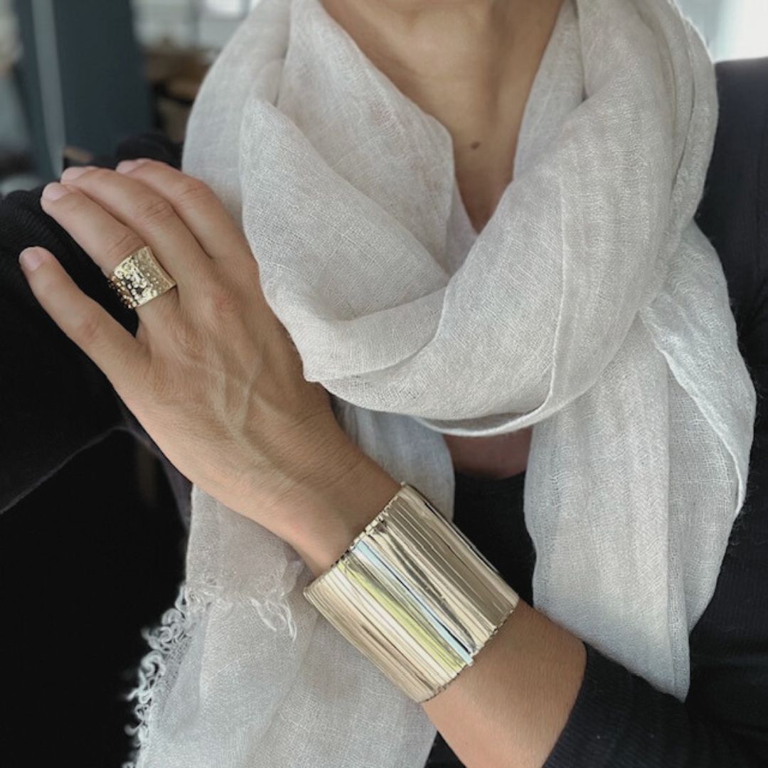 Wide Celestial Cuff with fine vertical detailing, worn with a black top and white scarf.