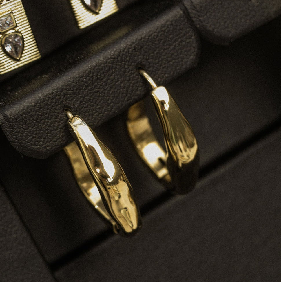 Gold Organic Hoop Earrings in a black jewellery box, showing their curved profile and polished finish.