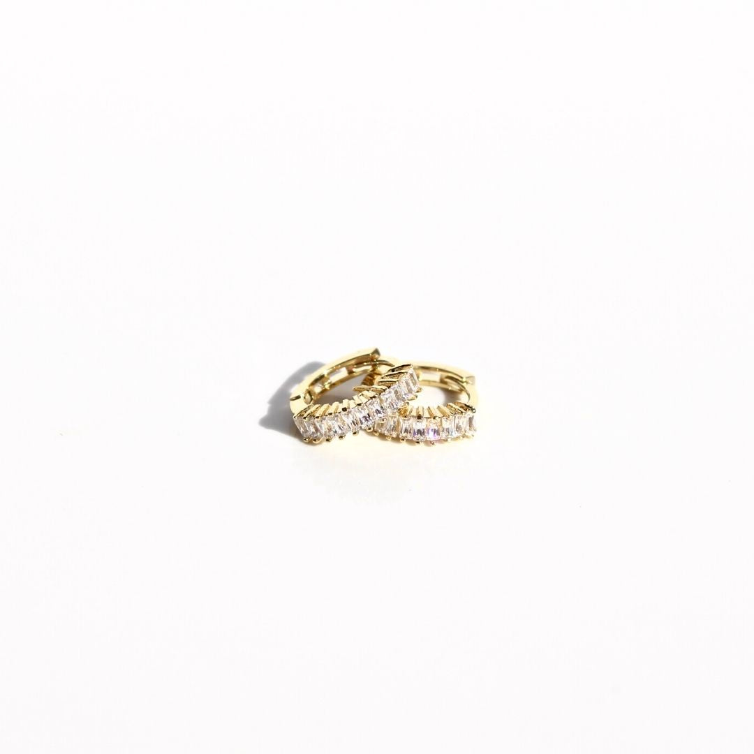 Pair of gold Petite Marquise Sleeper earrings on a white background, showing clear zirconias and hinged hoop closures.