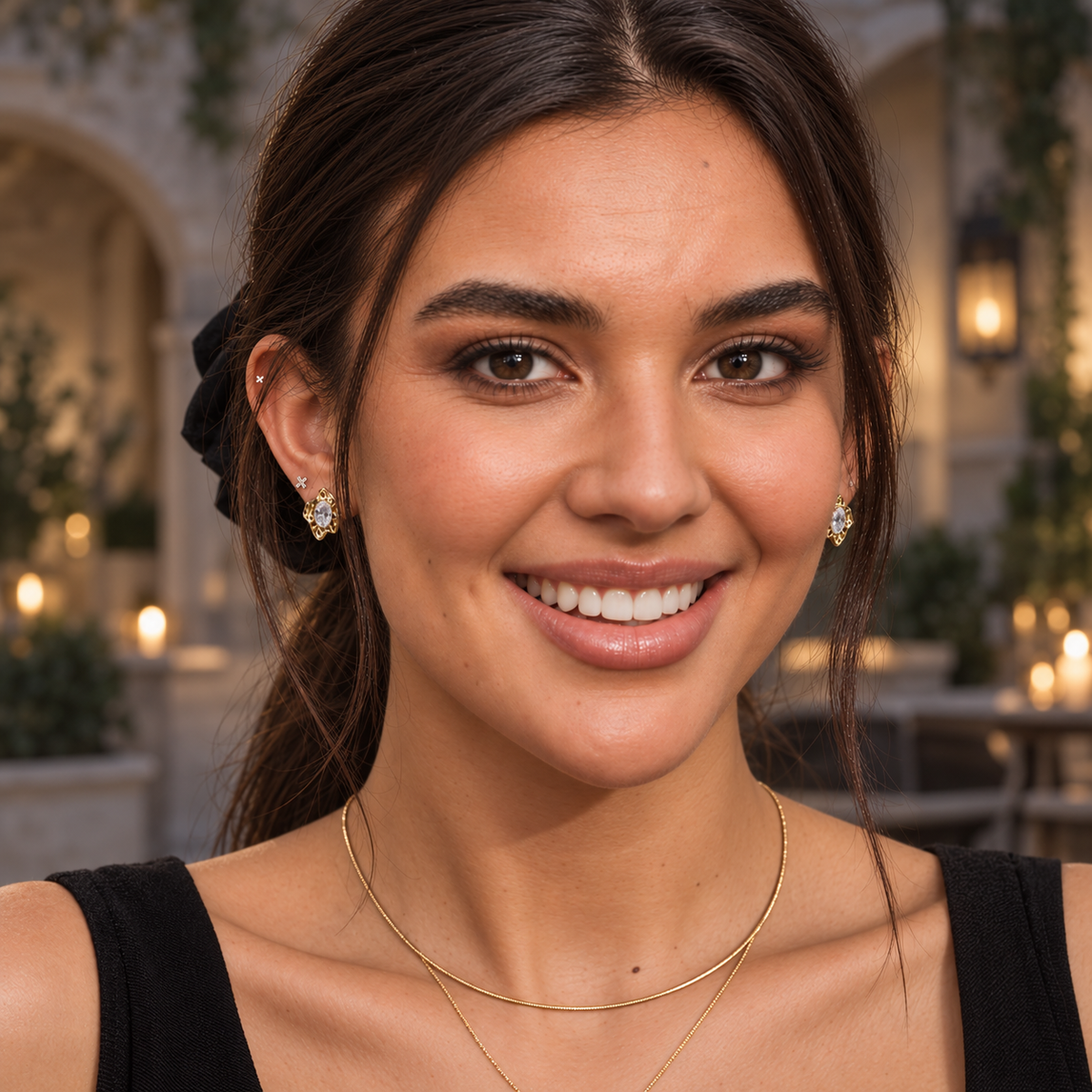 Model facing the camera in a black dress, showing both gold Rough Diamond Stud Earrings in a courtyard setting.