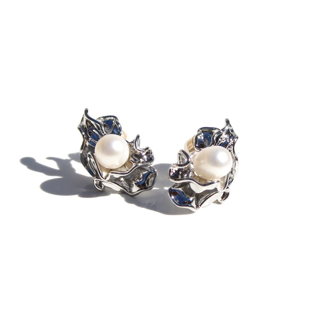 Pair of silver Ruched Pearl Earrings on a white background, with natural pearls and sculptural folded settings.