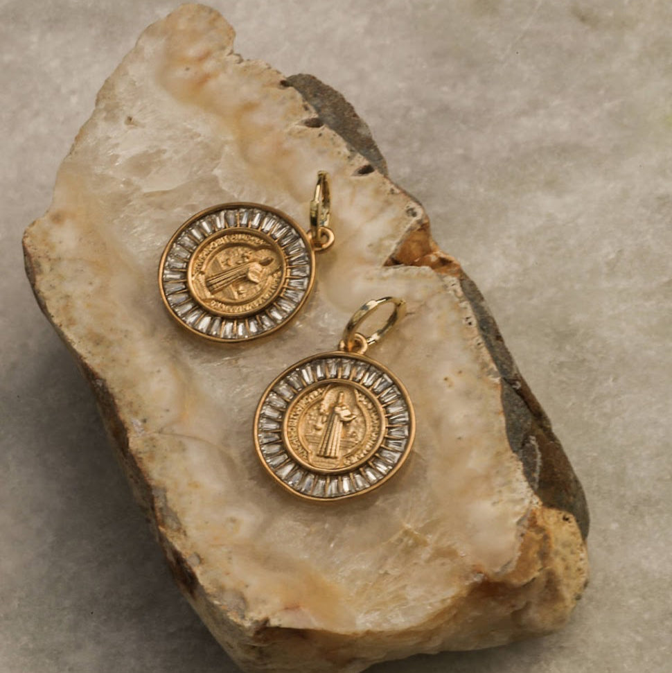 Gold pendants on a rock with a neutral background
