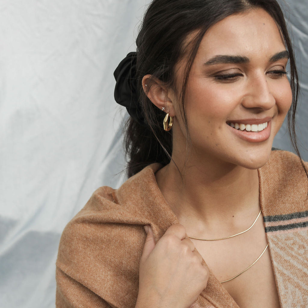 Woman wearing a print scarf with a neutral background