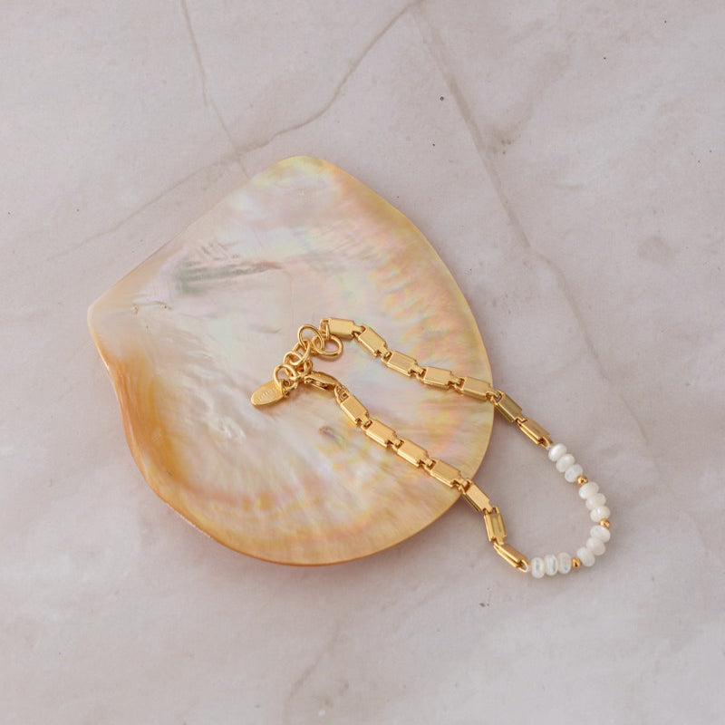 A stunning bracelet by Queen of the Foxes featuring gorgeous pearls and a flat-link chain with 18k gold plating. Perfect for stacking or wearing solo, with an adjustable tail chain for the ideal length.