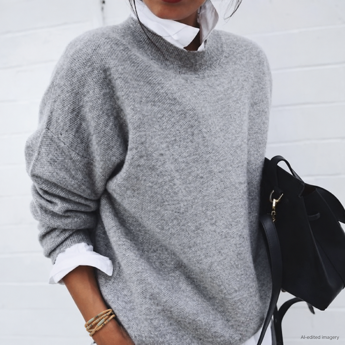 Dusky Gold Natural Wood Wrap worn loosely around a model’s wrist, styled with a grey jumper, white shirt and black handbag.