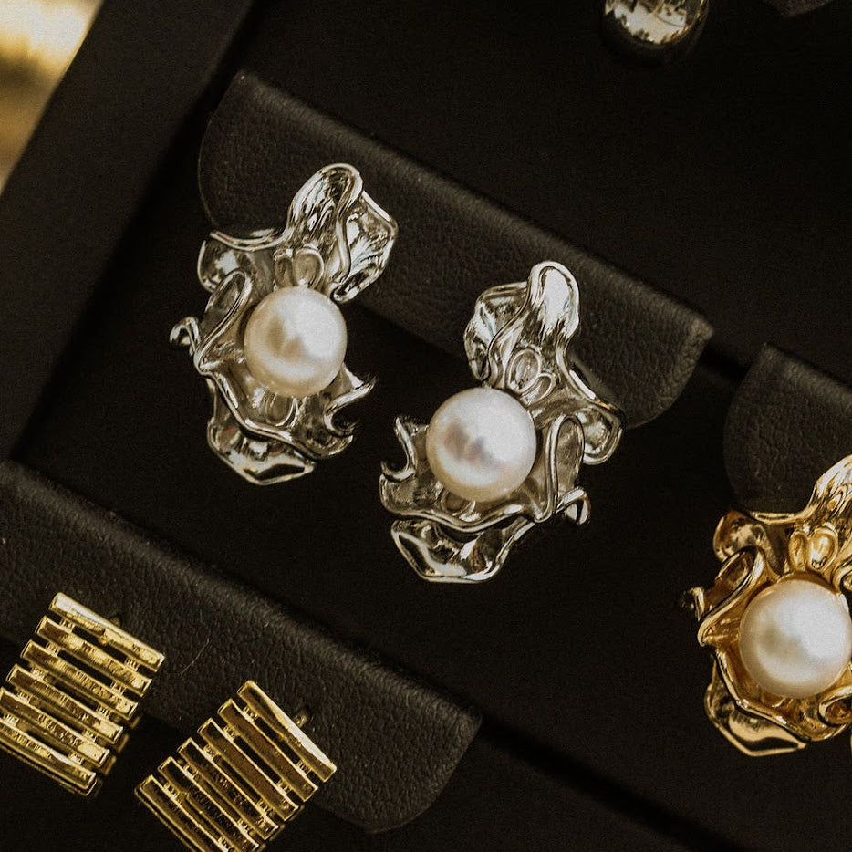 Silver Ruched Pearl Earrings on a dark jewellery tray, showing the pearl centres and irregular polished folds.