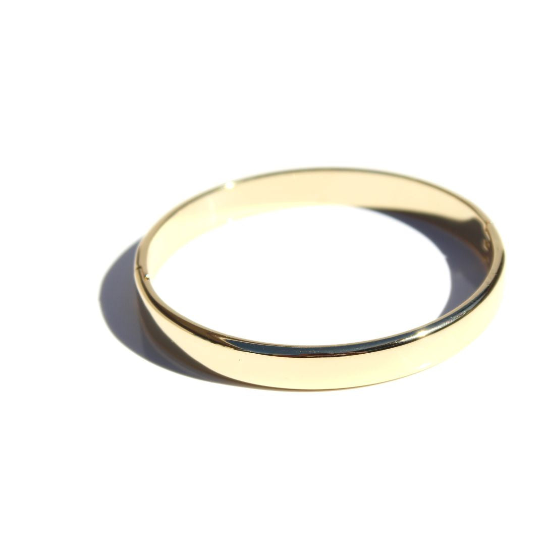 Single Solid Bangle in polished gold-plated brass on a white background, showing its smooth band and closure.