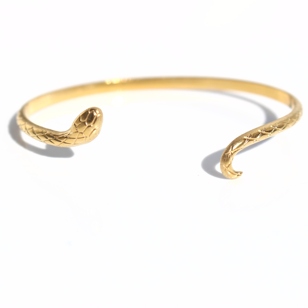 Gold snake cuff bracelet with open-ended serpent design and textured scale detailing on a white background.